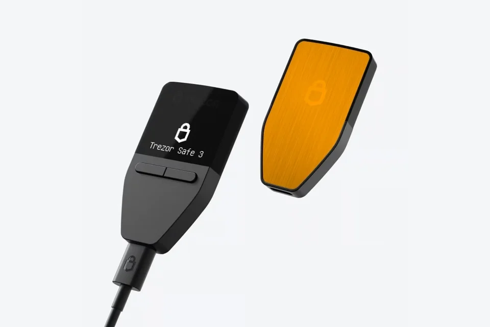 Front and orange back of a Trezor Safe 3 Bitcoin-only, with a USB cable connected.