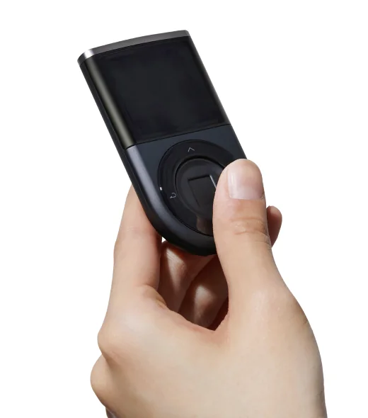 A hand holds a DCENT Biometric Wallet with a thumb on the central fingerprint sensor and four surrounding navigation buttons; the screen is blank.