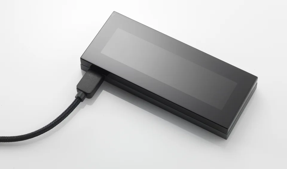 KeepKeys Herstellerfoto zeigt die Vorderseite der Hardware-Wallet mit leerem OLED-Bildschirm und einem seitlich angeschlossenen Kabel.