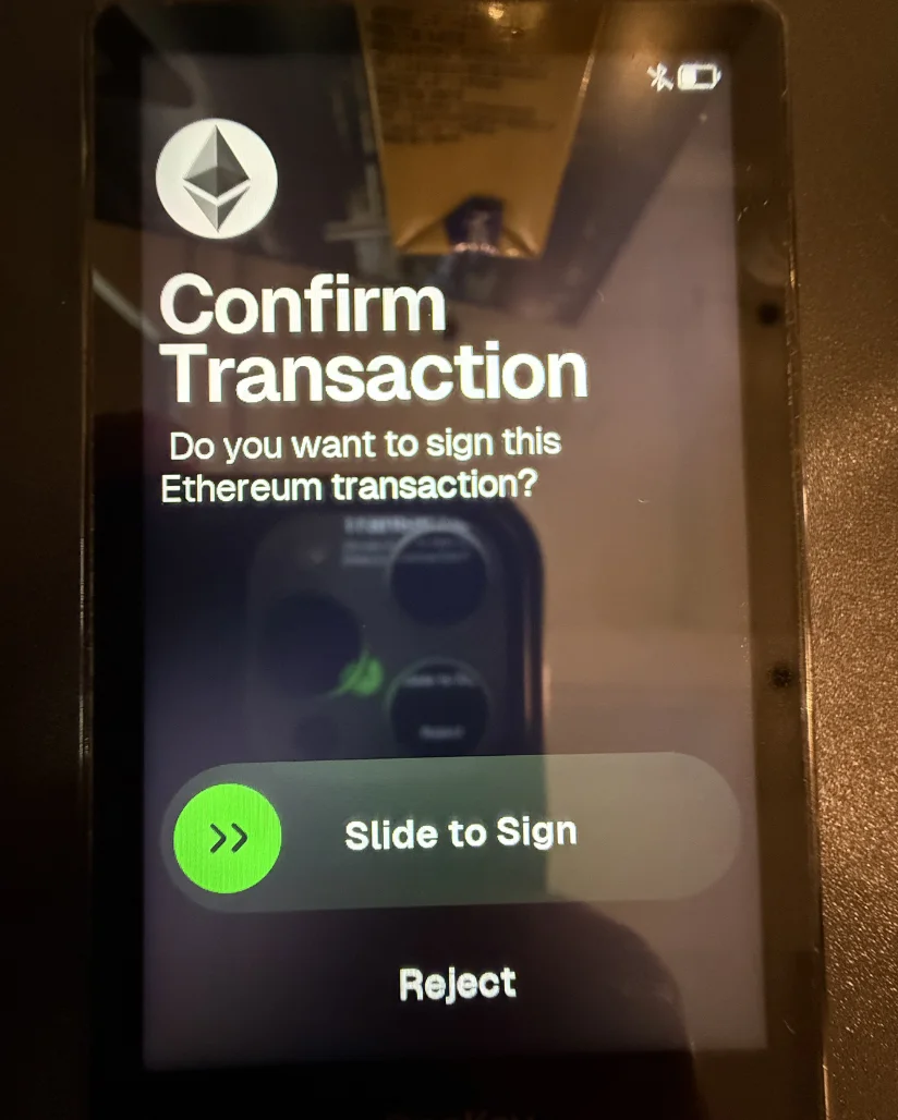 OneKey Pro asks for confirmation of an Ethereum transaction, with Slide to Sign and Reject controls.