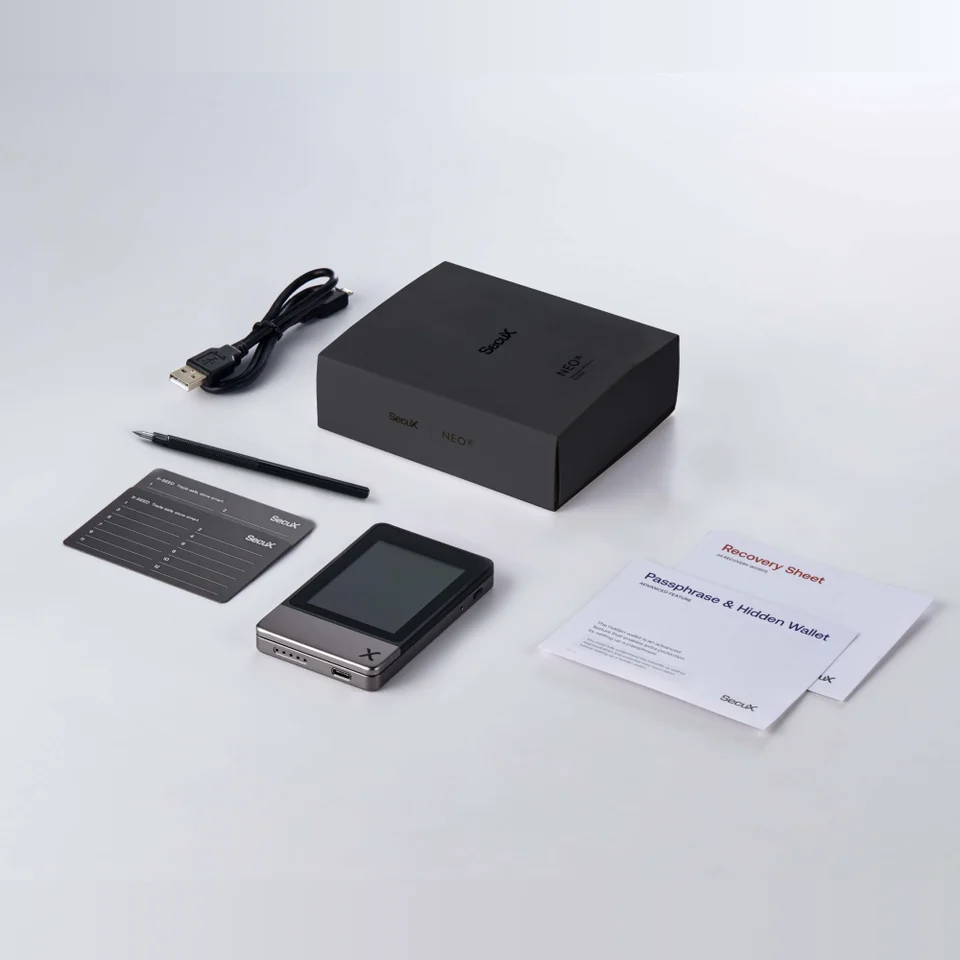 SecuX Neo-X junto a placas X-SEED sin rellenar, un lápiz grabador, hojas de papel para las palabras de recuperación, un cable USB y su caja.