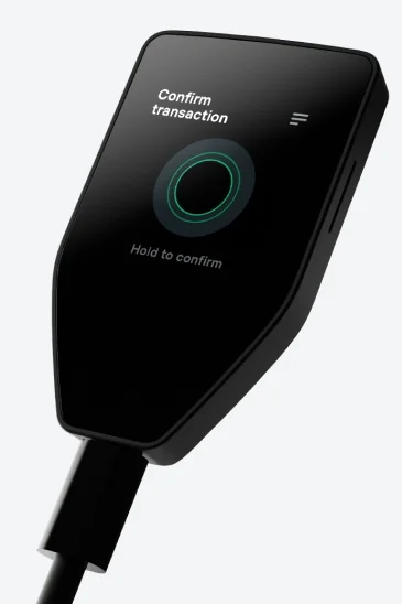 Trezor Safe 5 showing “Confirm transaction” and “Hold to confirm” on its touchscreen.